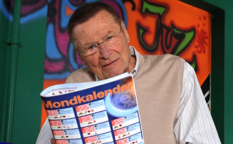 Alois (Erich Hallhuber) schaut sich skeptisch den Mondkalender an. – Bild: BR/​Marco Orlando Pichler