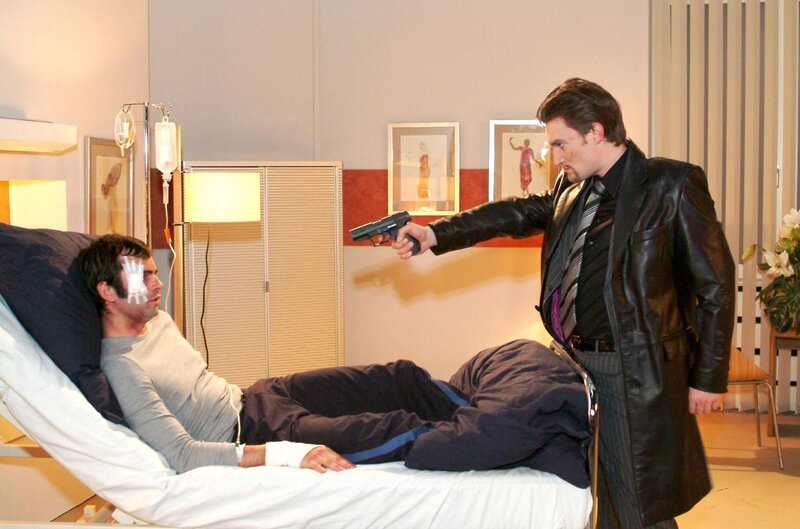 Der skrupellose Richard (Karim Köster, r.) wähnt sich am Ziel – und bedroht David (Mathis Künzler, l.) mit einer Waffe. – Bild: SAT.1 /​ Monika Schürle