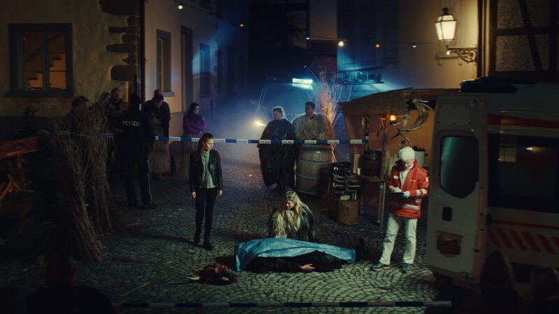 Karina Droste (Hilde Dalik) kniet vor ihrem ermordeten Mann Hubert Droste (André Rohde) draußen auf einer nächtlichen Straße. – Bild: ZDF und Lukas Gnaiger