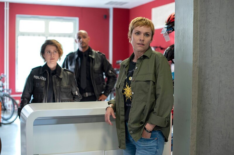 Nina Sieveking (Wanda Perdelwitz, l.) und Lukas Petersen (Patrick Abozen, M.) erkundigen sich bei Anke Jaitner (Gundula Niemeyer, r.) nach deren Angestellten Jeanette Preuß. – Bild: ARD/​Thorsten Jander