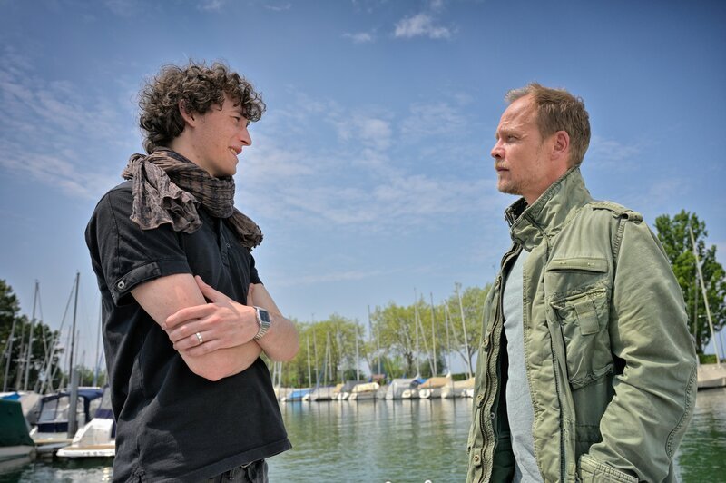 Pit Adams (Jonathan Lade, l.) und Micha Oberländer (Matthias Koeberlin, r.) stehen zusammen am Hafen und unterhalten sich. – Bild: Patrick Pfeiffer /​ ZDF
