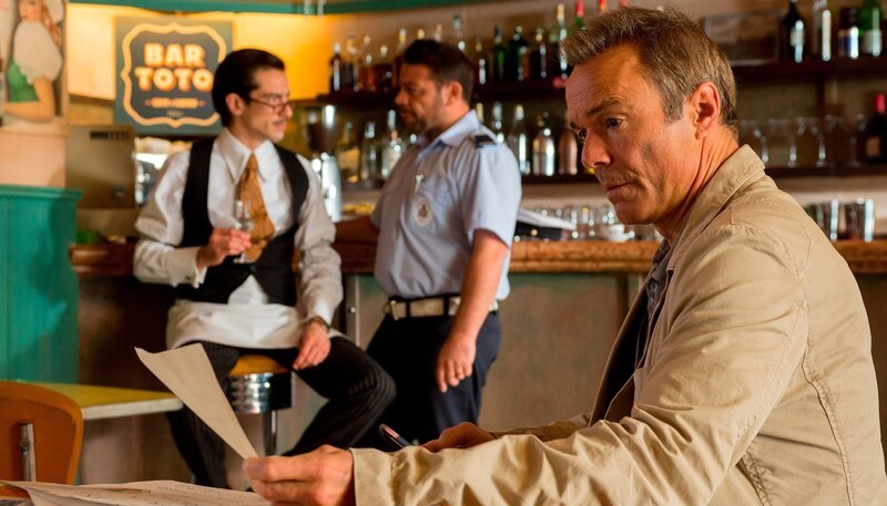 Während der Poliziotto (Leonardo Negri, Mitte) sich bei Toto (Stefano Bernardin) erkundigt, informiert sich Ex-Polizist Thilo Gruber (Hannes Jaenicke, re.) über die Olivenpreise. – Bild: ARD Degeto/​Gordon Mühle