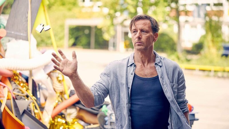 Stefan (Hendrik Duryn) fängt lässig das brennende Feuerzeug, mit dem Maya vor dem gesammelten Müllberg auf dem Schulhof stand. – Bild: RTL /​ Frank Dicks