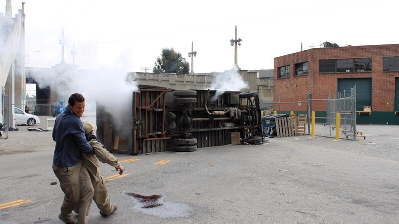 Episode 101 Burning Car and Lake Rescue. Bear Grylls dragging victim away to safety. – Bild: Discovery Communications /​ Delbert Shoopman