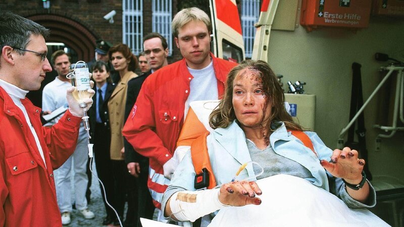 Dagmar (Kristiane Kupfer) wird abtransportiert. Sie ist nach Tagen verzweifelter Befreiungsversuche aus dem Schacht völlig verrückt geworden (Sanitäter Komparsen). – Bild: RTL Deutschland