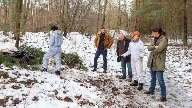Ins Zentrum der Ermittlungen rückt ein Waldflurstück, das wegen gefährlicher Munitionsfunde gesperrt ist. Kriminaltechnikerin Roswitha Prinzler (Silke Matthias, 2.v.r.) führt Reuter (Udo Kroschwald, M.), Pöhlmann (Dominic Boeer, 2.v.l.) und Joost (Nike Fuhrmann, r.) zu einem mysteriösen Fund. Zufällig in der Nähe befindet sich auch die Waldhütte von Bettina Kruse, in die sie sich regelmäßig zum Arbeiten zurückzieht. Oder gibt es noch einen anderen Grund für ihre Aufenthalte? – Bild: ZDF /​ Meyerbroeker