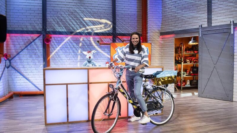 Woozle (li.) möchte am großen Preis von Woozlingen teilnehmen und dafür ein umweltfreundliches Rennauto erfinden. Doch das ist gar nicht so einfach, denn Woozles Ideen sind wie immer: komplett verrückt. Zum Glück hält Maria (re.) ein paar gute Ideen bereit. – Bild: SUPER RTL