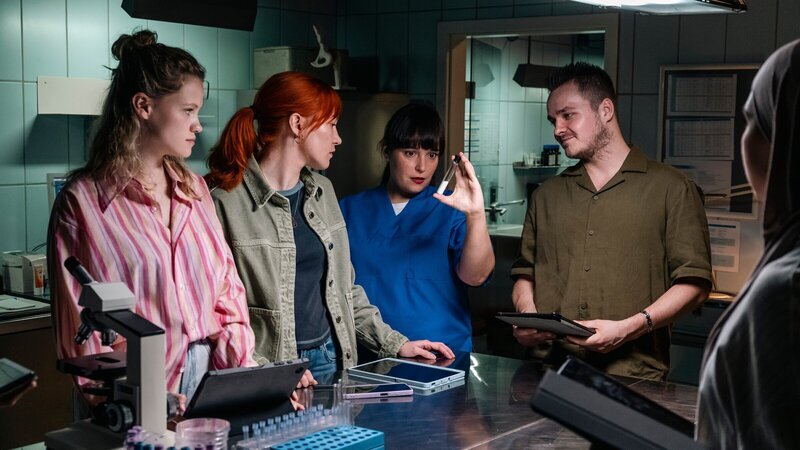 Dr. Westphal (Yulia Yáñez Schmidt, 2.v.r.) leitet einen Kurs zur Ahnenforschung an der Uni. Auch die Medizinstudentinnen Fiona Huss (Felina Zenner, l.) und Nela Bösfeld (Michelle Schneck, Mi.) sind davon fasziniert. Einen Tag später wird Nela tot aufgefunden. (Komparsen im Bild) – Bild: ZDF und Martin Rottenkolber