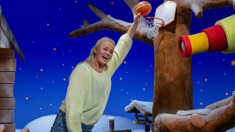 Singa bekommt eine Videobotschaft und hat einen Korb sowie einen Ball dabei. Um welche Sportart handelt es sich wohl? – Bild: KiKA