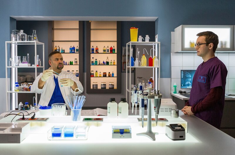 Olli (Arne Kertész, r.) teilt seine Diagnose des Patienten mit Dr. Moreau (Mike Adler, l.). – Bild: ARD/​Tom Fülle