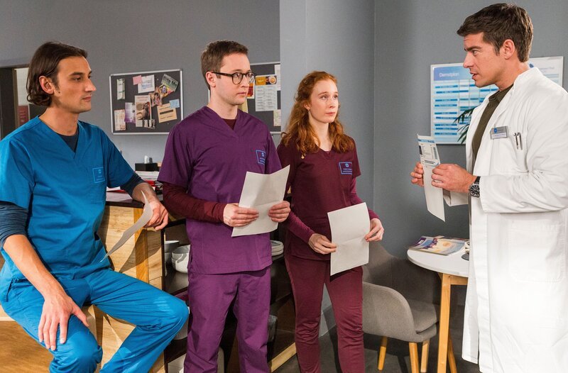 Ivo Maric (Jakob D’Aprile, l.), Oliver Probst (Arne Kertész, 2.v.l.) und Tamar Hummel (Linda Kummer, 3.v.l.) präsentieren Ben Ahlbeck (Philipp Danne, r.) ihre Ergebnisse der Bluttests. – Bild: ARD/​Tom Fülle