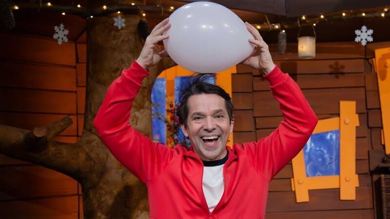 Juri erklärt, weshalb die Haare manchmal, nachdem man eine Mütze getragen hat, abstehen. Dafür hat er ein lustiges Experiment dabei. – Bild: KiKA