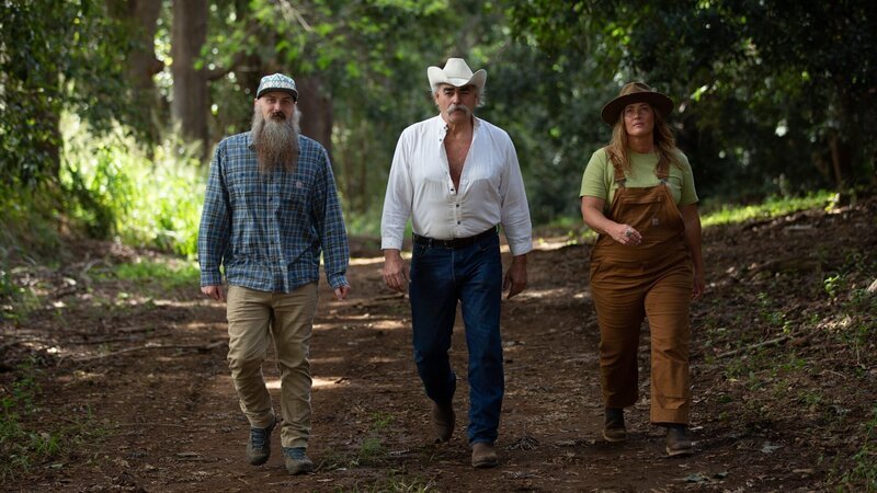 Portrait of Matt Raney, Marty Raney, and Misty Bilodeau walking down a paved path in the forest during hero shots. – Bild: Warner Bros. Discovery, Inc.
