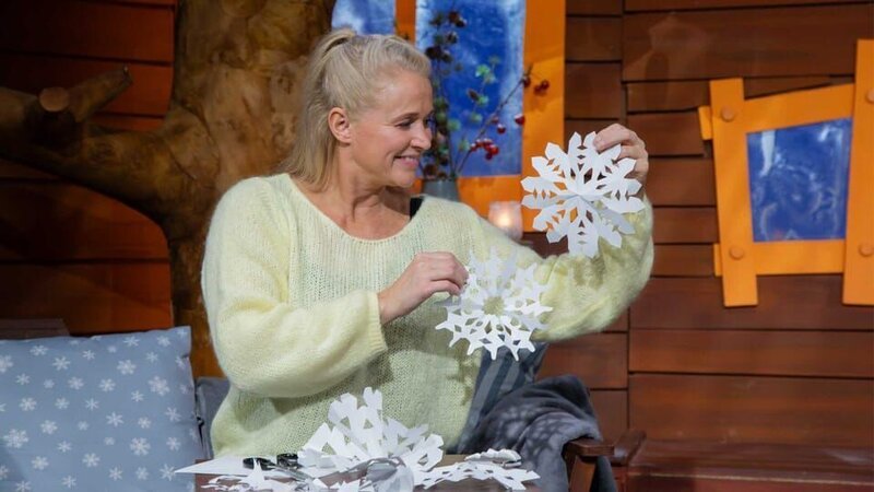 Singa zeigt wie man tolle Schneeflocken aus Papier basteln kann. Mit den unterschiedlichen Mustern kann man jedes Fenster verschönern. – Bild: KiKA