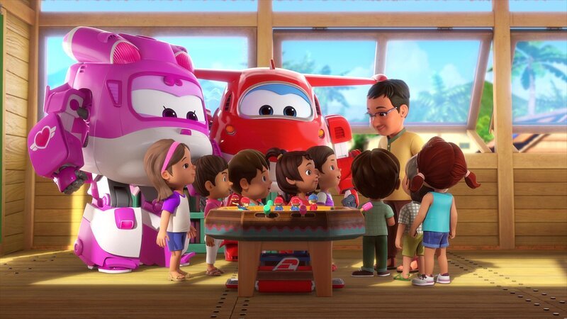 Die Schulkinder staunen, als die Super Wings Dizzy (li.) und Jett (hi.mi.) das Tisch-Cricket-Spiel ausliefern, das Ruma (vo.mi.) bestellt hat. Da ihr Schulboot zu klein ist, können die Kinder kein richtiges Cricket spielen. – Bild: FUNNYFLUX /​ ALPHA