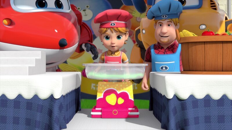 Olivier (mi.) stellt Zuckerwatte aus französischem Gemüse her, um sie in seiner Schule bei der „Messe der Kulturen der Welt“ an seinem Frankreich-Stand auszustellen. Dazu hat er bei den Super Wings eine „Gemüsewatte-Maschine“ bestellt, die Jett (li.) und Donny (re.) ihm ausliefern. – Bild: FUNNYFLUX /​ ALPHA ALL RIGHTS RESERVED