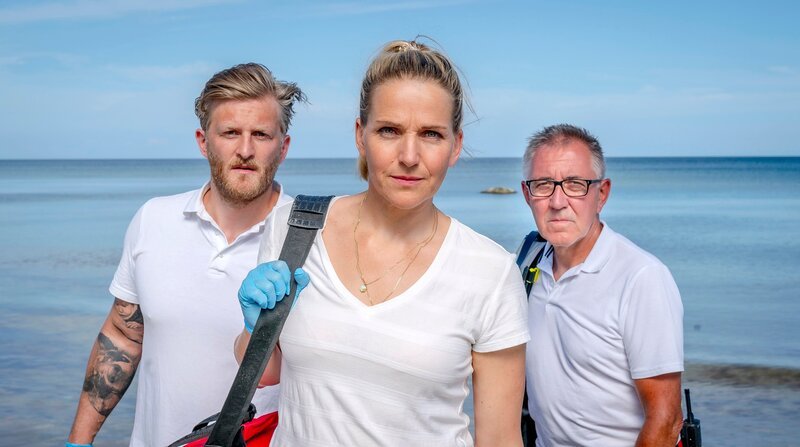 Nora (Tanja Wedhorn), ihr Kollege Lars (Bo Hansenl, li.) und ein weiterer Sanitäter (Wolfgang Stadler) eilen zum Strand – Bild: ARD Degeto/​Boris Laewen /​ ZDF und ARD Degeto/​Boris Laewen