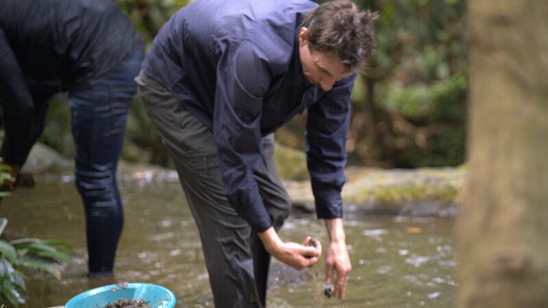 Parker Schnabel panning underneath waterfall – Bild: Warner Bros. Discovery, Inc.