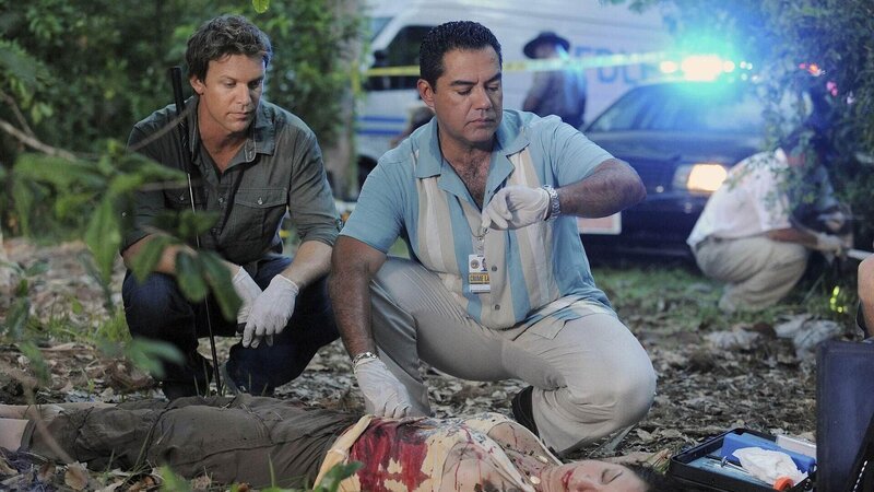Wie von dem verletzten Zeugen beschrieben, wurde eine weibliche Leiche gefunden. Jim Longworth (Matt Passmore, l.) und Carlos Sanchez (Carlos Gomez) machen sich ein erstes Bild von dem Tatort und dem Opfer. – Bild: TVNOW