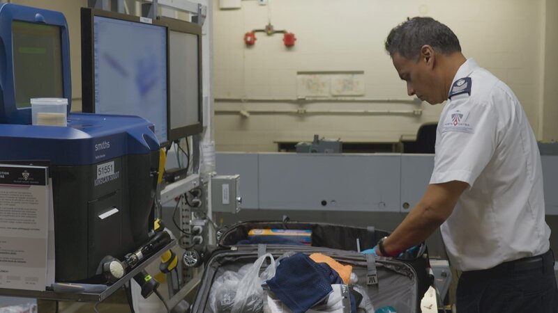 Ash Gobin, Screening Officer, CATSA, searches a suitcase after a scan revealed an object that looked like a sheet explosive. – Bild: Arrow International Media Ltd & Cantina Media