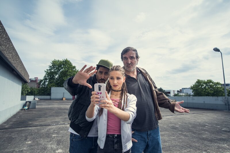 Fotosession mit Folgen: Sol (Eko Fresh, l.), Lisa (Cosima Henman, M.) und Ronald (Andreas Hoppe, r.). – Bild: ZDF/​Efe Cetinoezman