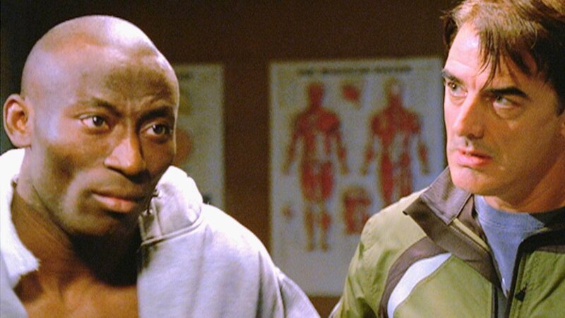 Detective Logan (Chris Noth, r.) verhört Chibueze (Babs Olusanmokun), der bei einer Schießerei verletzt wurde. Warum will der Nigerianer nicht auspacken? – Bild: MG RTL D