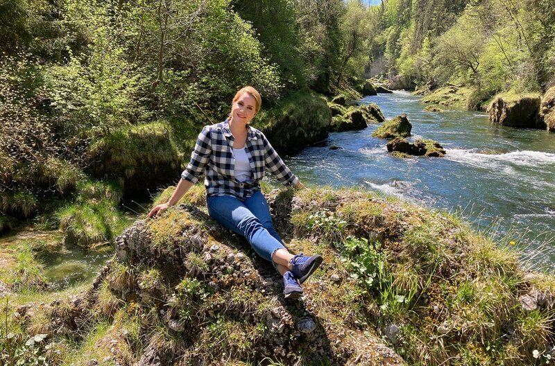 Judith Rakers an der Traun, einem beliebten Tauch- und Schnorchelgebiet am Traunfall-Wasserfall. – Bild: WDR/​Bavaria Entertainment GmbH/​Bastian Straschewski