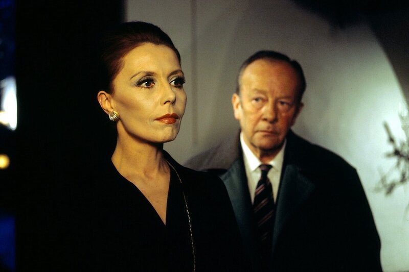 Irene Triberg lebt in einer Umgebung, wie sie sich nur ein begütertes Künstlerehepaar leisten kann: Ein schönes Haus, Bücher, Schallplatten alles, was der geistigen Anregung dienen kann. Deshalb wirkt der Besuch von Kommissar Keller wie der Einbruch in eine fremde Welt. Honorarfrei – nur für diese Sendung bei Nennung ZDF und Neue Münchner Fernsehproduktion – Bild: ZDF und Neue Münchner Fernsehproduktion /​ Neue M¸nchner Fernsehproduktion