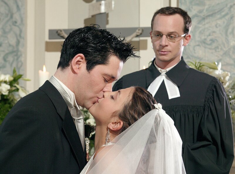 Nach reichlicher Überzeugungsarbeit aller wagt sich Philipp (Thomas Koch, li.) ein zweites Mal vor den Altar und den Pfarrer (Tobias Schulze, re.). Und dieses Mal läuft Arzu (Arzu Ritter) nicht davon. – Bild: NDR/​MDR/​Krajewski