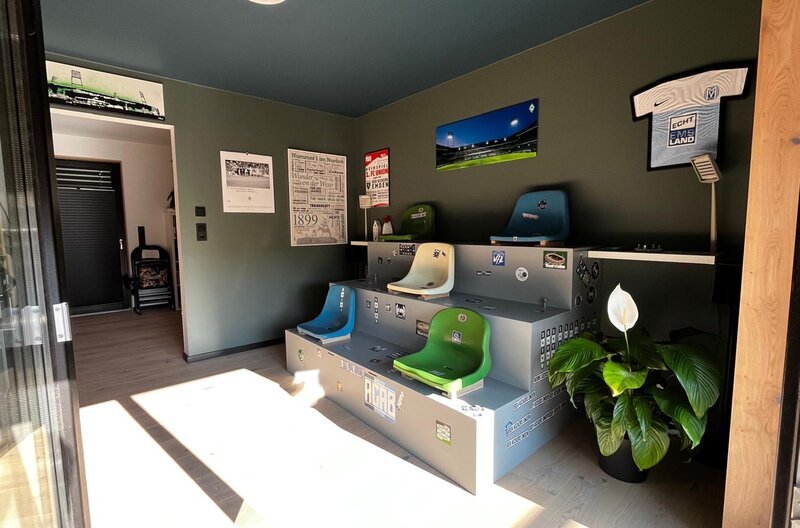 Das Fußballzimmer ist der zentrale Ort im Haus mit original Sitzschalen aus dem Bremer Weser-Stadion. – Bild: NDR/​Rainer Mueller-Delin