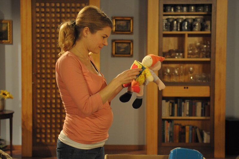 Uschi (Silke Popp) schaut sich das alte Spielzeug von Yvi und Christian an, welches Trixi ihr gegeben hat. – Bild: BR/​Jo Bischoff