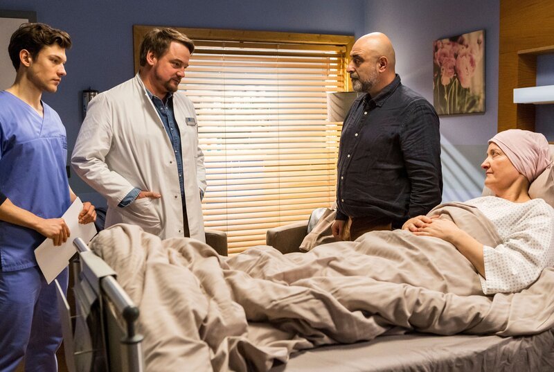 Carl Fischer (Özgür Karadeniz, 2.v.r.) erhofft sich, dass Marc Lindner (Christian Beermann, 2.v.l.) mit Hilfe von Florian Osterwald (Lion Wasczyk, l.) seiner großen Liebe Corinna Dohme (Annedore Kleist, r.) mehr Lebenszeit durch eine OP verschaffen kann. – Bild: ARD/​Tom Fülle