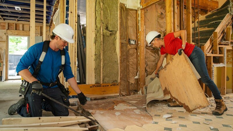 Michael (left) and Sherry Holmes (right) peel up some old linoleum flooring in this kitchen as seen on HGTV’s Holmes Family Rescue Season 2 – Bild: Warner Bros. Discovery, Inc. or its subsidiaries and affiliates. All rights reserved.