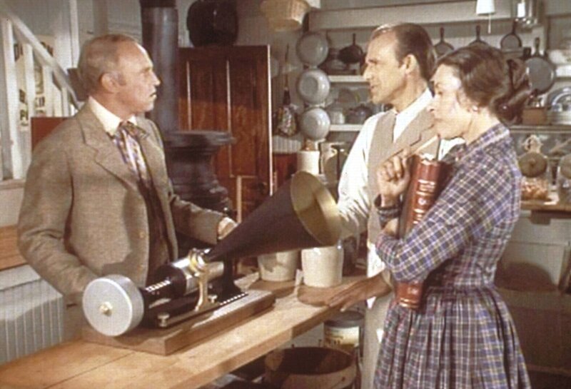 Mr. Oleson (Richard Bull, M.) und Mrs. Oleson (Katherine McGregor, r.) wissen nicht so recht, was sie mit Mr. Godfreys (George Furth, l.) Sprechmaschine anfangen sollen. – Bild: Sat.1 Gold