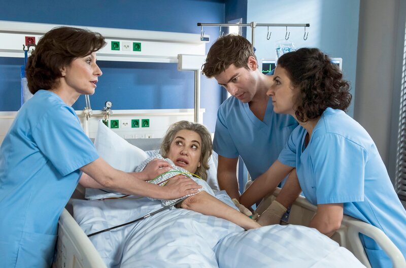 Badri (Brigitte Karner, M.) traut Ben (Philipp Danne, 2.v.r.) nicht. Leyla (Sanam Afrashteh, r.) und Dr. Patzelt (Marijam Agischewa, l.) haben alle Hände voll zu tun, Badri zu beruhigen. – Bild: ARD/​Jens Ulrich Koch