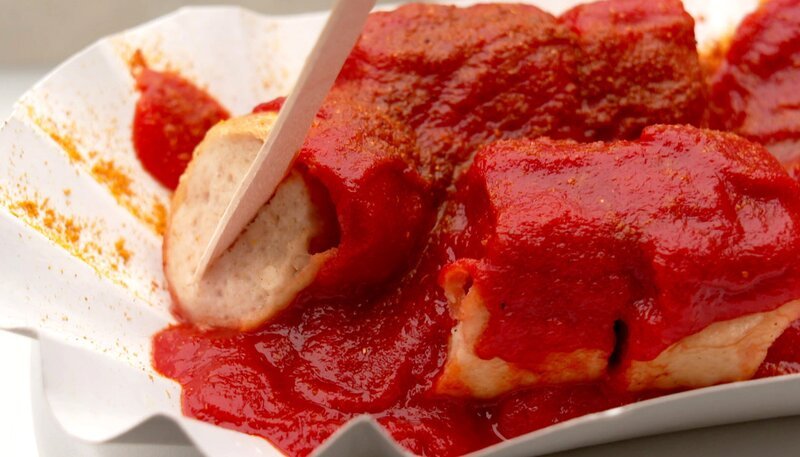 Schnell mal was essen gehen, aber wo? Berlins Imbiss-Buden sind legendär. Viele locken mit Spezialitäten. Ob Falafel, Fish & Chips, halbe Hähnchen, Spätzle, herzhafte Germknödel oder Plow, das usbekische Reisgericht – es gibt alles in der Stadt. Ein Besuch bei Berlins Kultimbissen und in kleinen Restaurants. – Berliner Currywurst. – Bild: rbb/​Frank Kremer