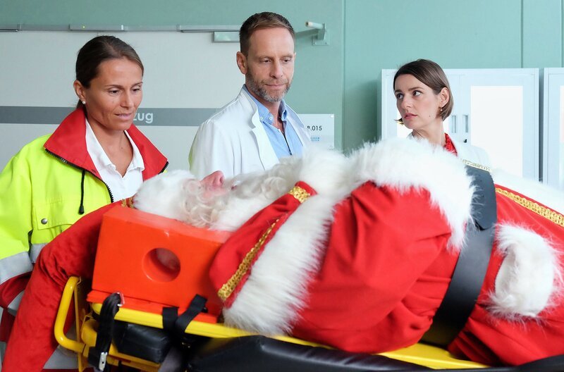 Weihnachtsmann (Armin Dallapiccola, vorne); (hinten v.l.n.r.) Notärztin (Caren Seifert); Dr. Kai Hoffmann (Julian Weigend); Dr. Maria Weber (Annett Renneberg) – Bild: MDR/​Sebastian Kiss