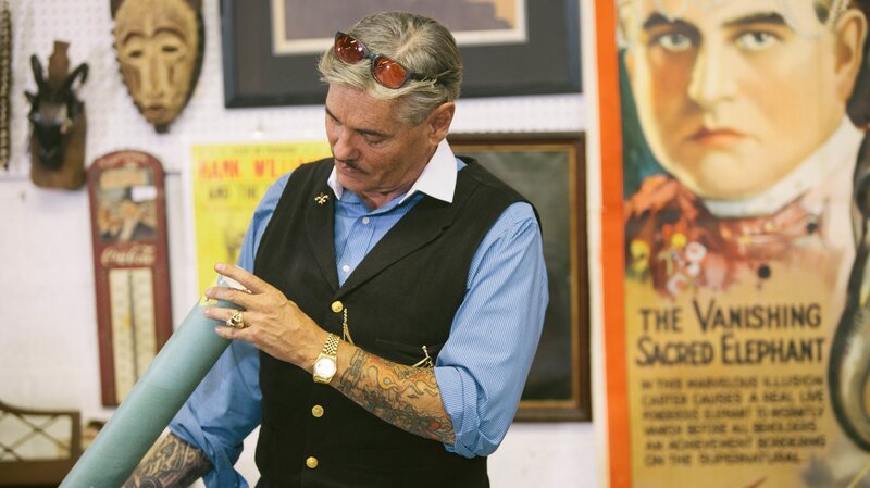 Intrigued, Billy checks out an old sealed tube labeled „80’s Stuff“ during the Nashville auction preview. – Bild: The Travel Channel, L.L.C.