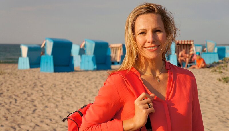 Moderatorin Andrea Grießmann am Strand von Ahrenshoop. – Bild: WDR /​ Linda Windmann