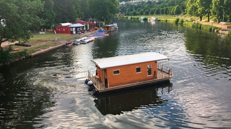 Fast wie im Bulli: Auch auf dem Hausboot ist man mit dem „Eigenheim“ auf Reisen. Anna-Lena Dörr probiert sich auch als Skipperin. – Bild: SWR/​Tom Lügger