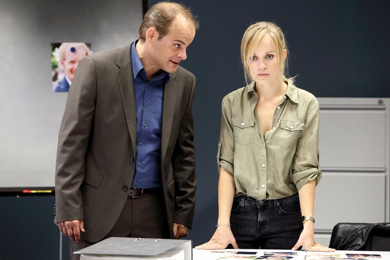 Julia Klug (Friederike Kempter, r.) ist wild entschlossen, den Heiratsschwindler zur Strecke zu bringen. Für Johannes Sonntag (Matthias Klimsa, l.) gehört dieser Fall in einen Groschenroman und nicht in die Zuständigkeit des Betrugsdezernats. – Bild: NDR/​ARD/​Daniela Incoronato