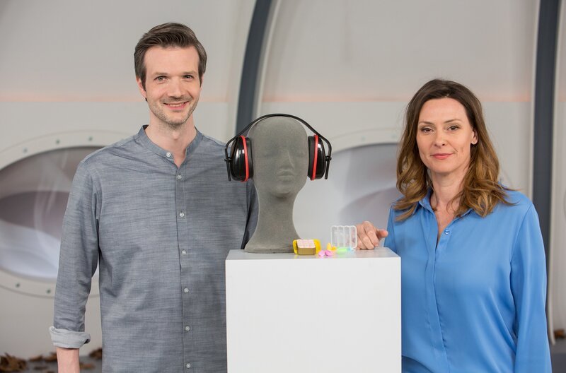 Anja Reschke (r.) und Adrian Pflug (l.) beschäftigen sich mit unserem Gehör und wie eine kleine Pille unsere Ohren zukünftig vor Lärm schützen und Hörschäden erfolgreich abwehren könnte – in „Wissen vor acht – Zukunft“. – Bild: ARD/​Michael Boehme