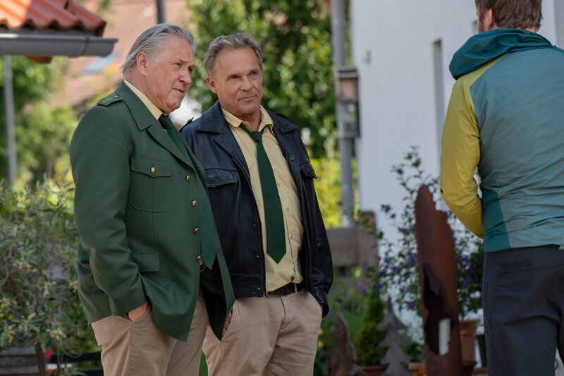 Hubert (Christian Tramitz, m.) und Girwidz (Michael Brandner, l.) befragen Mark Neumayr (Thilo Prothmann, r.) zu seinem Alibi. – Bild: Leonine /​ Thomas Neumeier