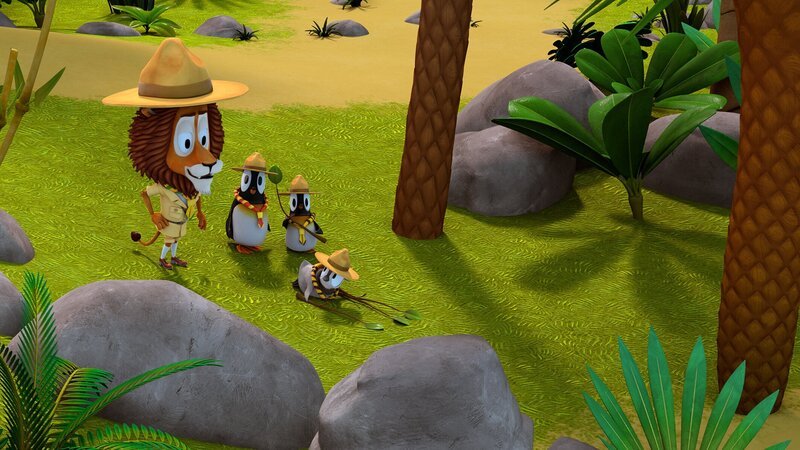 Pfadfinderleiter Lionel (Löwe) gibt den Pinguinen Anweisungen, wie man sich an wilde Tiere heranpirscht. – Bild: ZDF/​Gaumont Animation/​PP Animation III Inc.