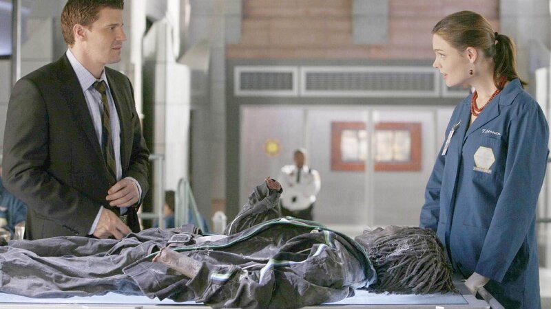 Dr. Brennan (Emily Deschanel) teilt Agent Booth (David Boreanaz) erste Untersuchungsergebnisse im Fall einer mumifizierten Leiche mit, die in der Wand einer Diskothek gefunden wurde. – Bild: TVNOW /​ FOX