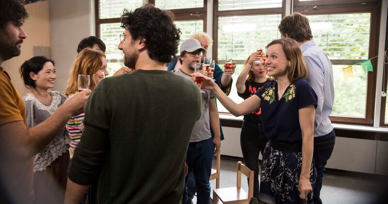 Anita (Nadja Becker) verkündet stolz ihre Schwangerschaft und stößt auf diese mit den Mitgliedern der Elterninitiative an. – Bild: TOM TRAMBOW BVK /​ ZDF