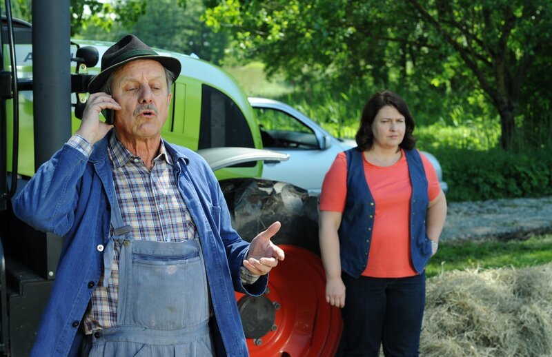 Schattenhofer erhält einen Anruf vom Landrat. Von links: Bürgermeister Schattenhofer (Werner Rom) und Monika Vogl (Christine Reimer). – Bild: BR/​Marco Orlando Pichler