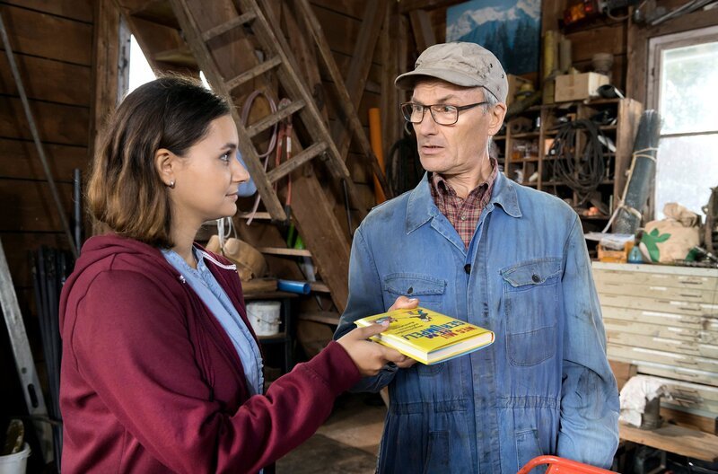 Jenny (Julia Obst) hat ein Buch beim Aufräumen gefunden und überreicht dies Karl (Peter Schell) – mit großer Wirkung. – Bild: SWR/​Alexander Kluge