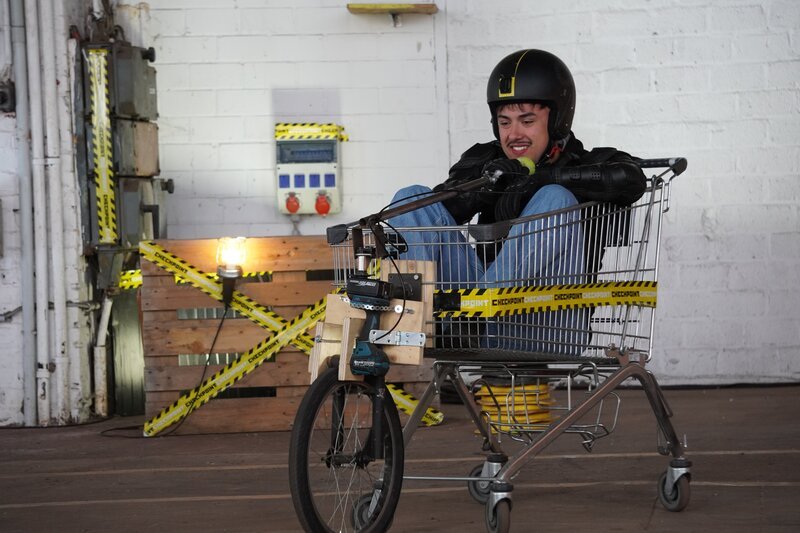 Was lässt sich mit Pfandgut denn alles schönes anstellen, bevor man es endgültig zurück gibt? Moritz testet einen umgebauten Einkaufswagen und cruist damit durch die Checkpoint-Halle. – Bild: ZDF/​Katharina Barnick