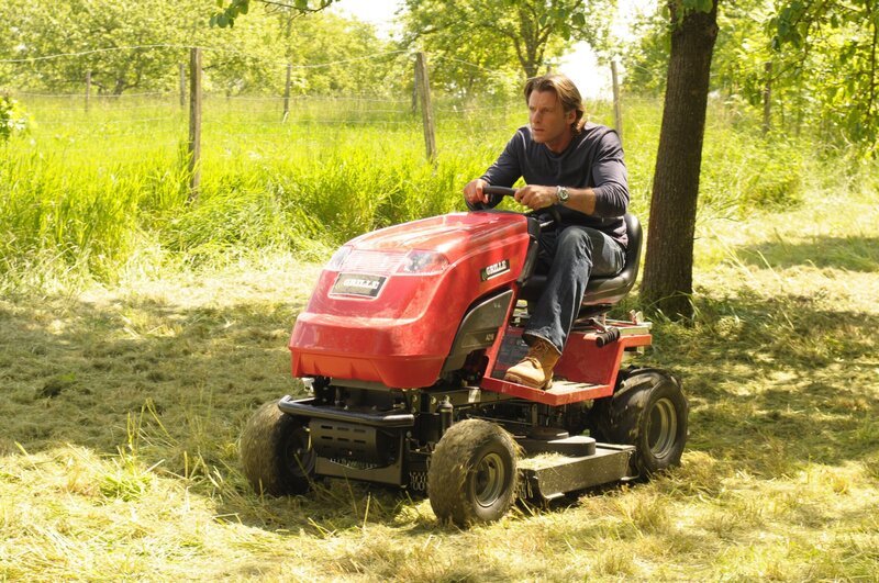 Sebastian (Herbert Ulrich) versucht die Wiese genauso schnell wie Mike zu mähen. – Bild: BR/​Jo Bischoff